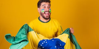 SIGA no Brasil: parcerias com o governo e estudo estratégico sobre o futebol Homem com a bandeira do Brasil celebrando