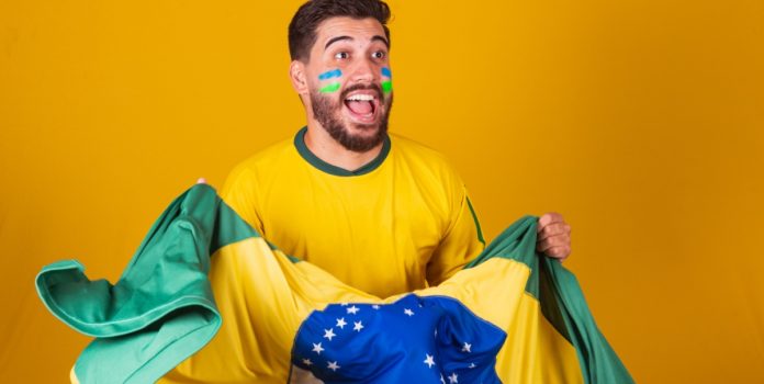Homem com a bandeira do Brasil celebrando