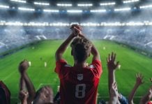 Torcida de futebol celebrando em estádio
