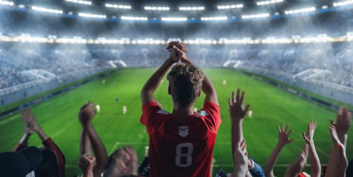 Torcida de futebol celebrando em estádio