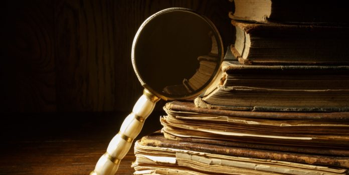 Lupa apoiada em livros