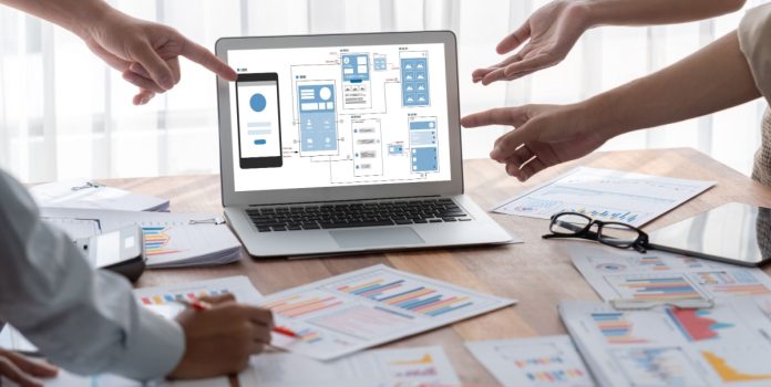UX-e-UI-nas-apostas_-como-interfaces-inteligentes-retêm-jogadores Desenvolvedores trabalhando na UX e UI de um site