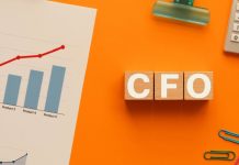 Escrivaninha com gráfico, clipes, calculadora e a sigla CFO em cubos de madeira