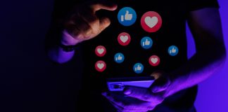 Influenciador digital Daniel Fortune faz parceria com Faz1Bet para incentivar jogo responsável Homem mexendo no celular com ícones de curtida e de coração fora da tela