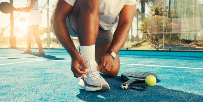 comissão-do-esporte-aprova-regras-para-impedir-bloqueio-de-recursos-de-apostas-para-o-esporte Homem amarrando os tênis com raquete e bola ao lado