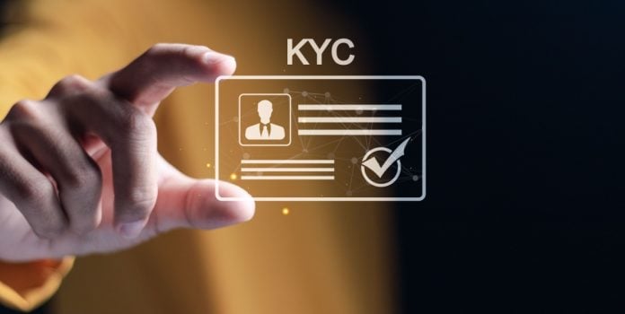 Homem segurando uma carteira virtual de identidade verificada escrito KYC em cima