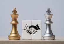 MC Games e EBAC fecham parceria para fortalecer proteção ao jogador Dois reis de xadrez com blocos de aperto de mão entre eles