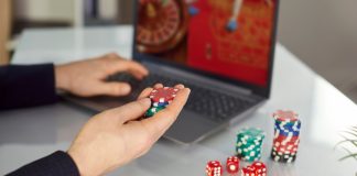 IAA lança projeto para tratamento da ludopatia no Brasil Homem sentado com fichas de cassino na mão e com computador jogando roleta