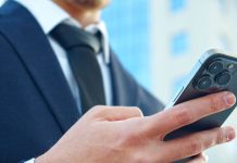 Homem de terno mexendo no celular