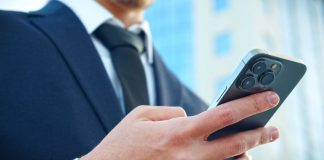 DF analisa PL que veta publicidade de apostas em contratos do governo Homem de terno mexendo no celular