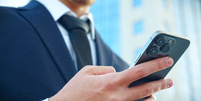 proibição-publicidade-apostas-governo-df-e-sc Homem de terno mexendo no celular