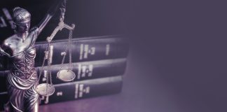 STF declara trechos da Lei das Apostas inconstitucionais Balança da justiça e livros de direito sobre a mesa