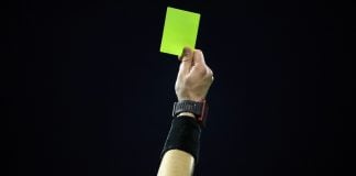 Rocco alerta que atletas são “o elo mais fraco” em manipulação de resultados Mão de juíz de futebol segurando cartão amarelo