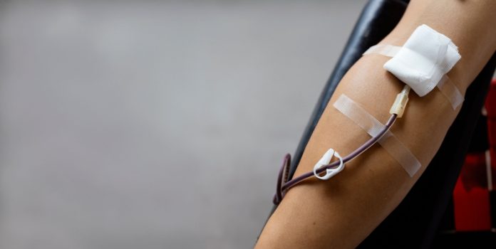 Braço de pessoa doando sangue