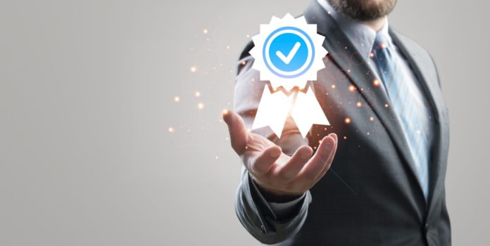 oddin.gg-recebe-certificação-da-gli-no-brasil Homem de terno segurando o símbolo de certificado virtual