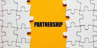 Fundo laranja escrito "Partnership" entre peças de quebra-cabeça