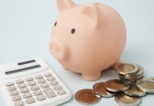 SOFTSWISS lança ferramenta para ajudar operadores a estimar custos de cassinos online Cofre de dinheiro em formato de porco, calculadora e moedas sobre a mesa