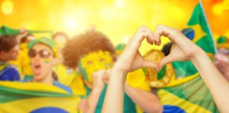 Silvia Paleari, IBIA: Brasil avança na integridade esportiva Brasileiros comemorando com bandeira, máscaras e fazendo coração com as mãos