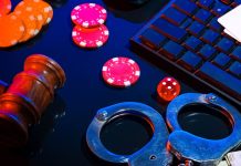 Algemas colocadas ao lado de dinheiro e fichas de pôquer em uma mesa preta com computador