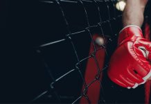 Betsul patrocina Guetho Fight Music Mão de um lutador de MMA com luva dentro no ringue