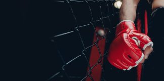 Betsul patrocina Guetho Fight Music Mão de um lutador de MMA com luva dentro no ringue