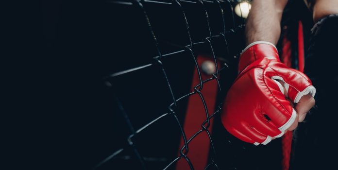 betsul-patrocina-guetho-fight-music Mão de um lutador de MMA com luva dentro no ringue