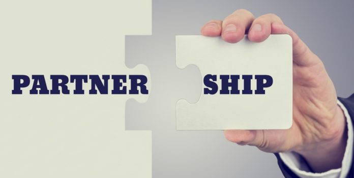fast-track-entra-na-américa-latina-com-atomo-gaming Mão de homem segurando metade da placa de Partnership