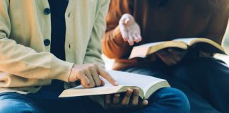 Duas pessoas com livros abertos estudando