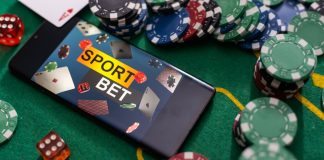 Medidas contra ludopatia e publicidade de apostas avançam em diferentes esferas do poder público Fichas de cassino e celular com a tela apresentando "apostas esportivas" em inglês sobre a mesa de jogo