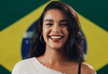 Mais apostas, menos riscos: Beanalytic observa mudança no comportamento dos brasileiros Mulher sorrindo com a bandeira do Brasil no fundo