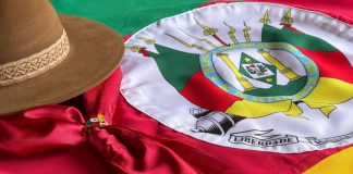 RS lança projeto de concessão de loterias Bandeira do Rio Grande do Sul com chapéu gaúcho ao lado