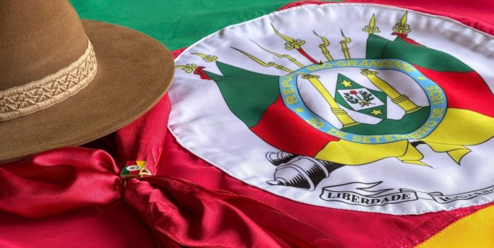 Bandeira do Rio Grande do Sul com chapéu gaúcho ao lado