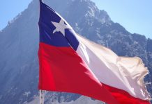 TG Lab foca na América Latina com novo Centro de Serviços Gerenciados no Chile Bandeira do Chile voando com uma montanha atrás