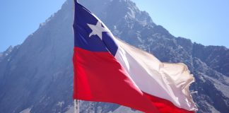 TG Lab foca na América Latina com novo Centro de Serviços Gerenciados no Chile Bandeira do Chile voando com uma montanha atrás
