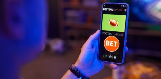 PL amplia proteção ao jogador e prevê sanções para empresas de apostas Mão segurando celular com imagem de 'bet'