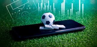 Uma bola de futebol e maços de dinheiro sob um smartphone, simbolizando apostas esportivas.