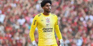 Hugo Souza, um homem negro alto, vestido a camisa amarela de goleiro do Corinthians, cujo patrocínio máster é a Esportes da Sorte.