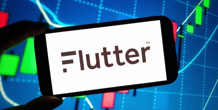 Flutter Mão segurando um smartphone cuja tela mostra a palavra Flutter.