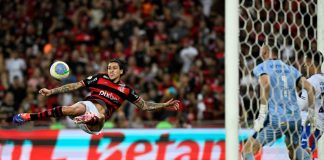 Homem dá chute de voleio em partida de futebol. Entain: Futebol sul-americano cresce no Top 50 de eventos mais apostados do mundo