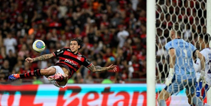 Futebol-sul-americano-cresce-no-Top-50-de-eventos-mais-apostados-do-mundo-em-2025 Homem dá chute de voleio em partida de futebol. Entain: Futebol sul-americano cresce no Top 50 de eventos mais apostados do mundo