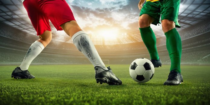 Jogadores-De-Futebol A imagem mostra as pernas de 2 jogadores e um está tentando driblar o outro.