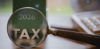 Palavra TAX sobre a mesa em frente ao calendário de 2026