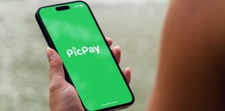 Mulher segurando celular aberto no aplicado do PicPay, que pediu IPO nos EUA com holding de apostas online