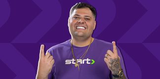 Homem de meia-idade, vestido com uma camisa roxa escrito Start, aponta os dois dedos indicadores para cima. Trata-se do influenciador digital Maumau, novo embaixador da Start Bet.