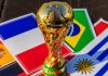 MESP promove jogo responsável durante Copa do Mundo de 2026 Troféu da Copa do Mundo sob bandeiras da França, Brasil, Espanha e Uruguai.