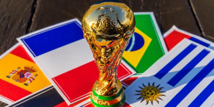 mesp-promove-jogo-responsavel Troféu da Copa do Mundo sob bandeiras da França, Brasil, Espanha e Uruguai.