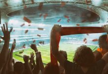 Torcedores de futebol celebram e fazem festa em estádio.