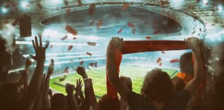 Torcedores de futebol celebram e fazem festa em estádio.