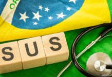 Estetoscópio e blocos de madeira escrito SUS sobre a bandeira do Brasil