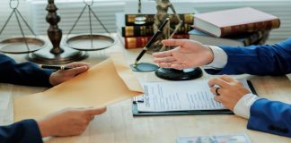 Duas pessoas analisando e trocando documentos.
